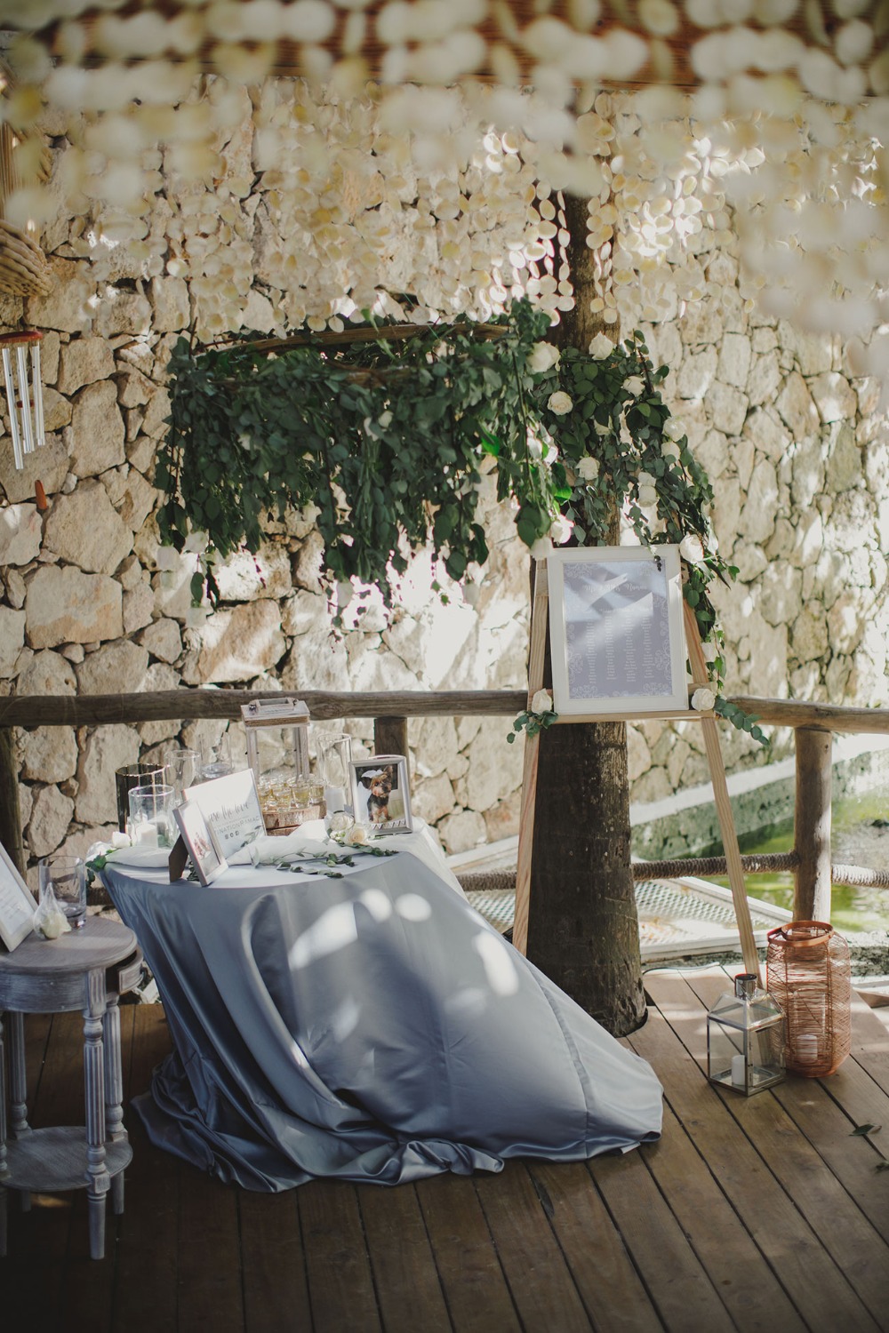 Wedding reception details with stone backdrop greenery