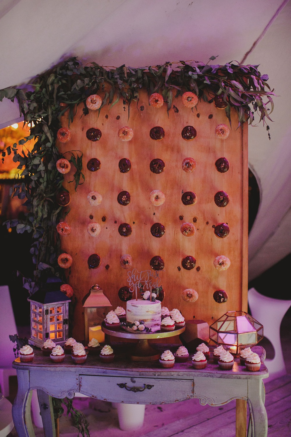 Donut wall cake and cupcakes at wedding reception party