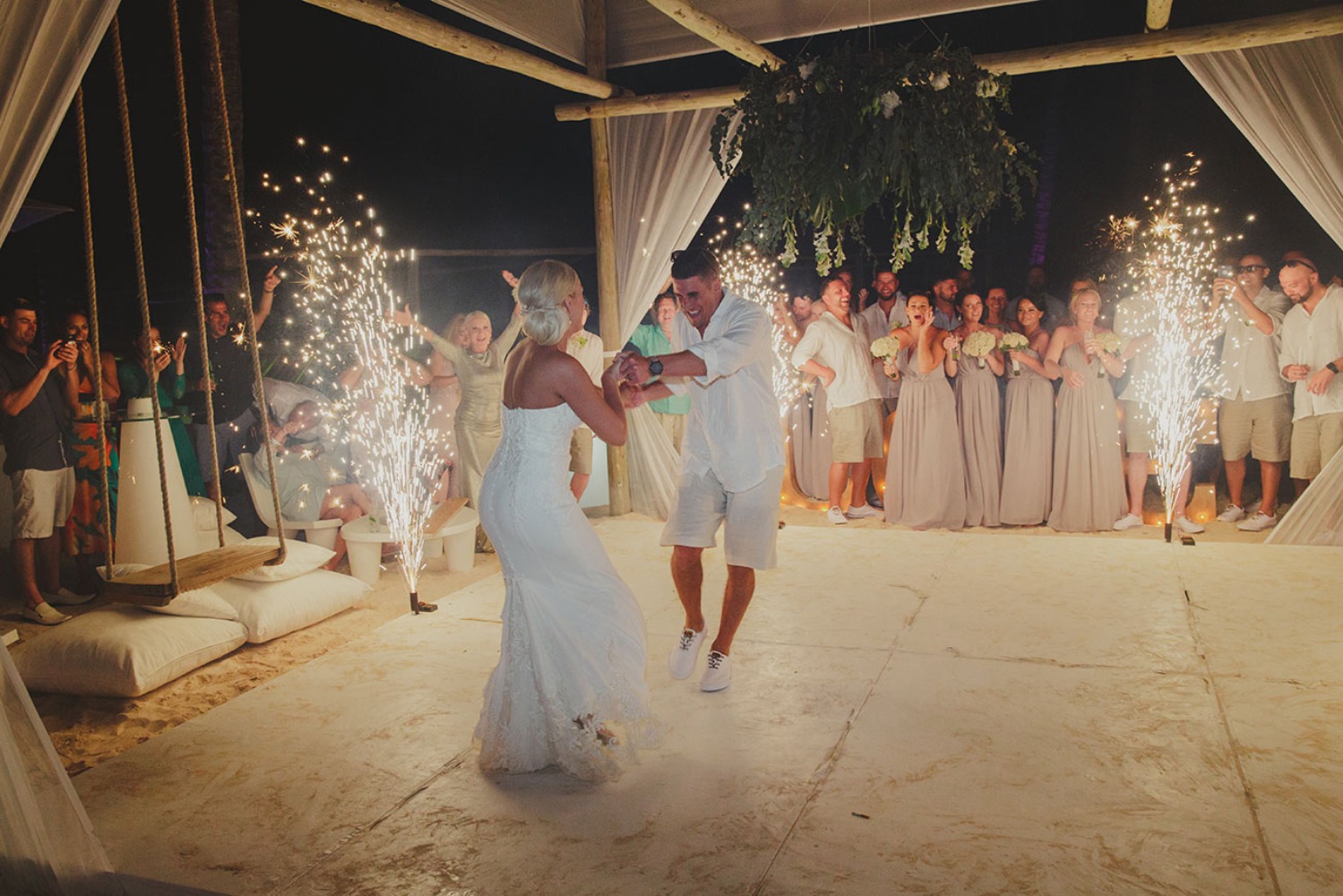Bride and groom dance with fireworks during a wedding party