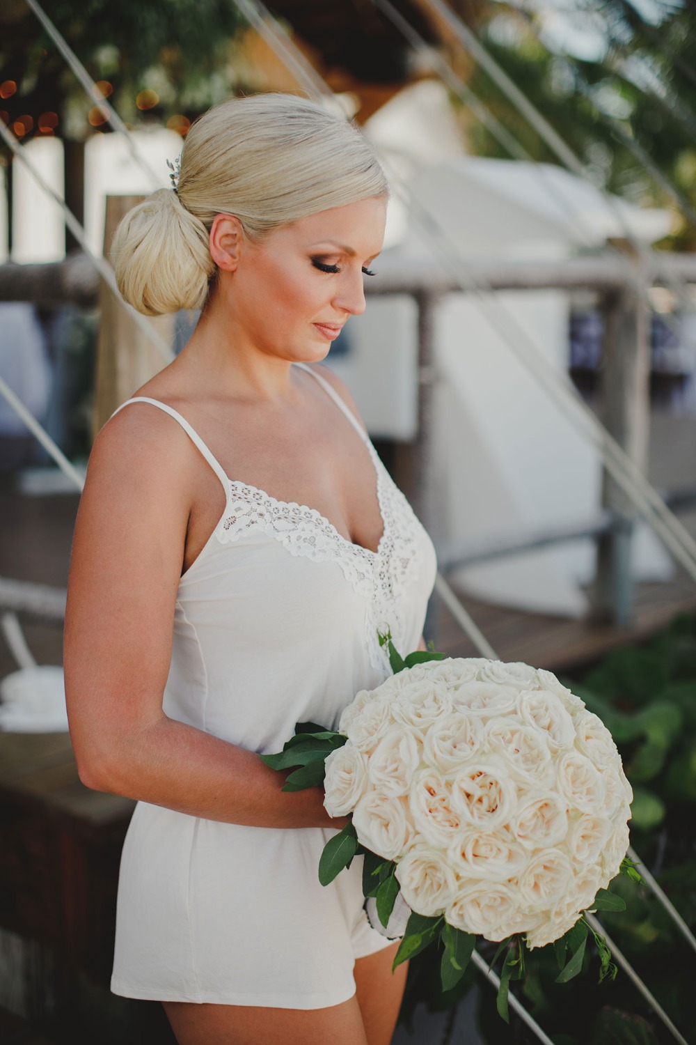 Beautiful bride holding a white rose bouquet, ready for a wedding
