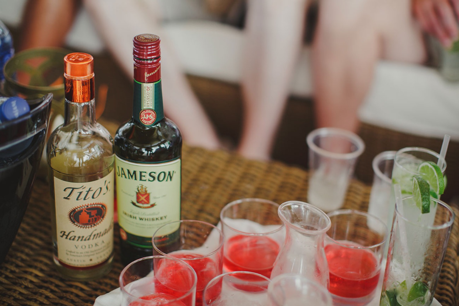 Bottles of vodka and whiskey, with red drinks and cocktails
