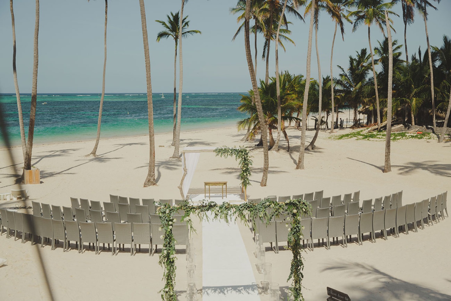 Beach wedding setup with ocean view and palm trees, ready to celebrate