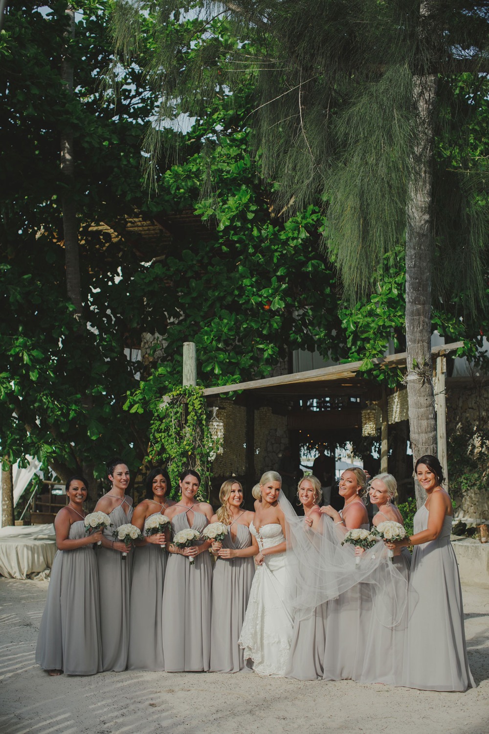 Bride and bridesmaids in elegant grey dresses at an outdoor wedding