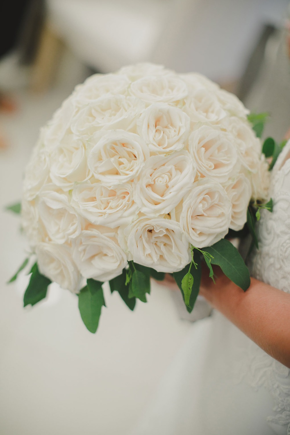 Elegant white rose bouquet held by a person, wedding flowers