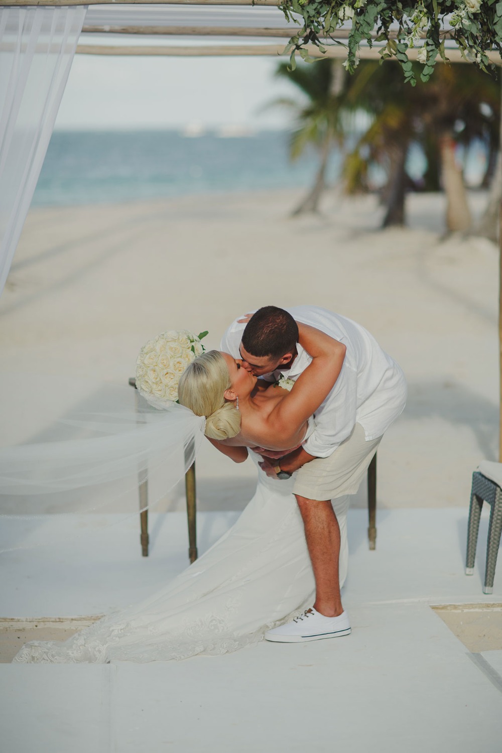 Newlyweds share a romantic kiss on a beautiful beach wedding