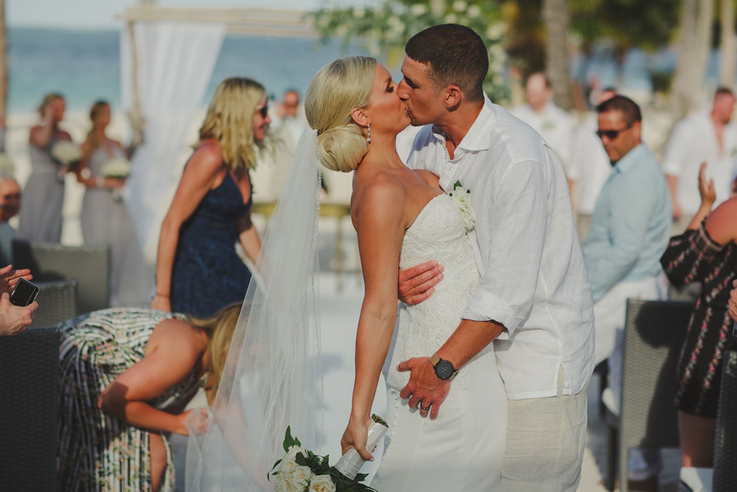 Newlyweds share a romantic kiss on the beach after their wedding