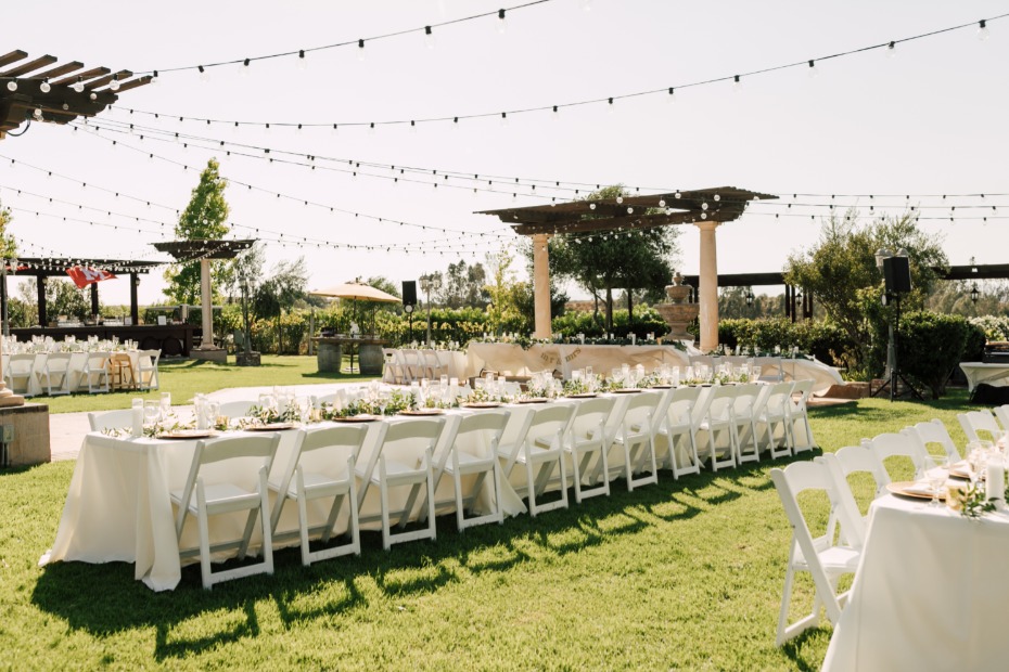 Outdoor wedding reception with long tables and string lights