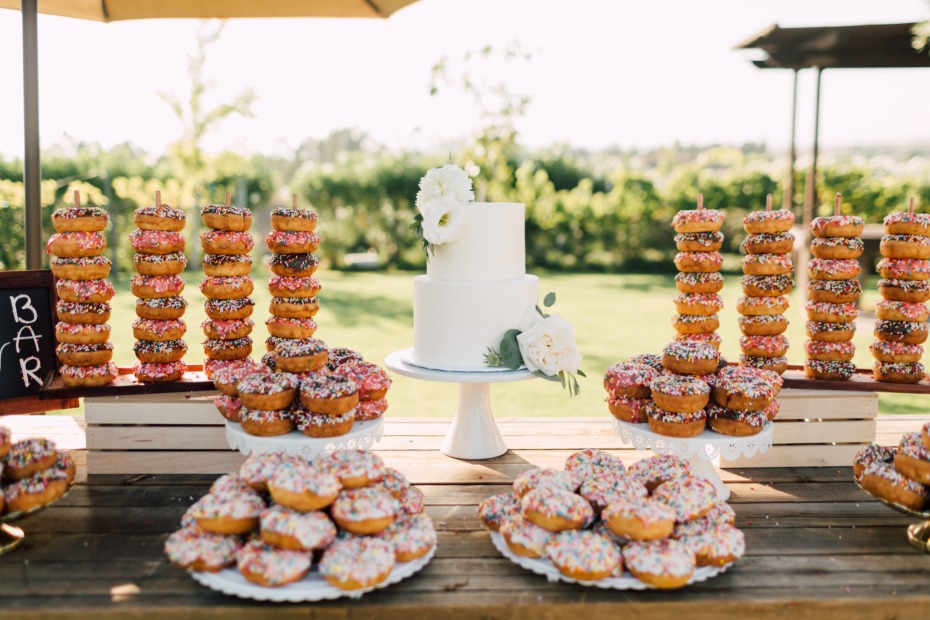 Wedding dessert bar with cake and donut towers