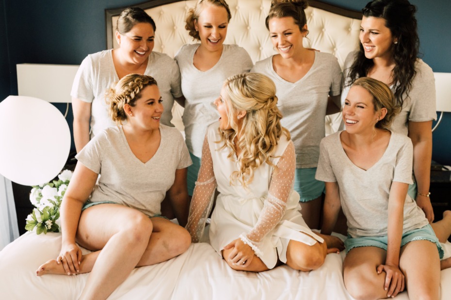 Bride and bridesmaids laugh together on the wedding day