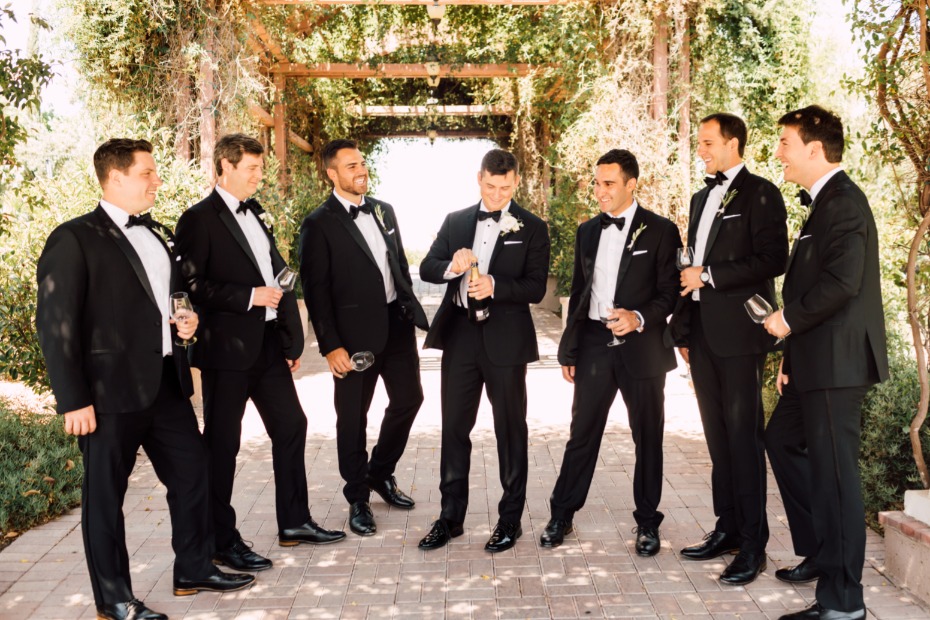 Groom and groomsmen celebrate with champagne at wedding
