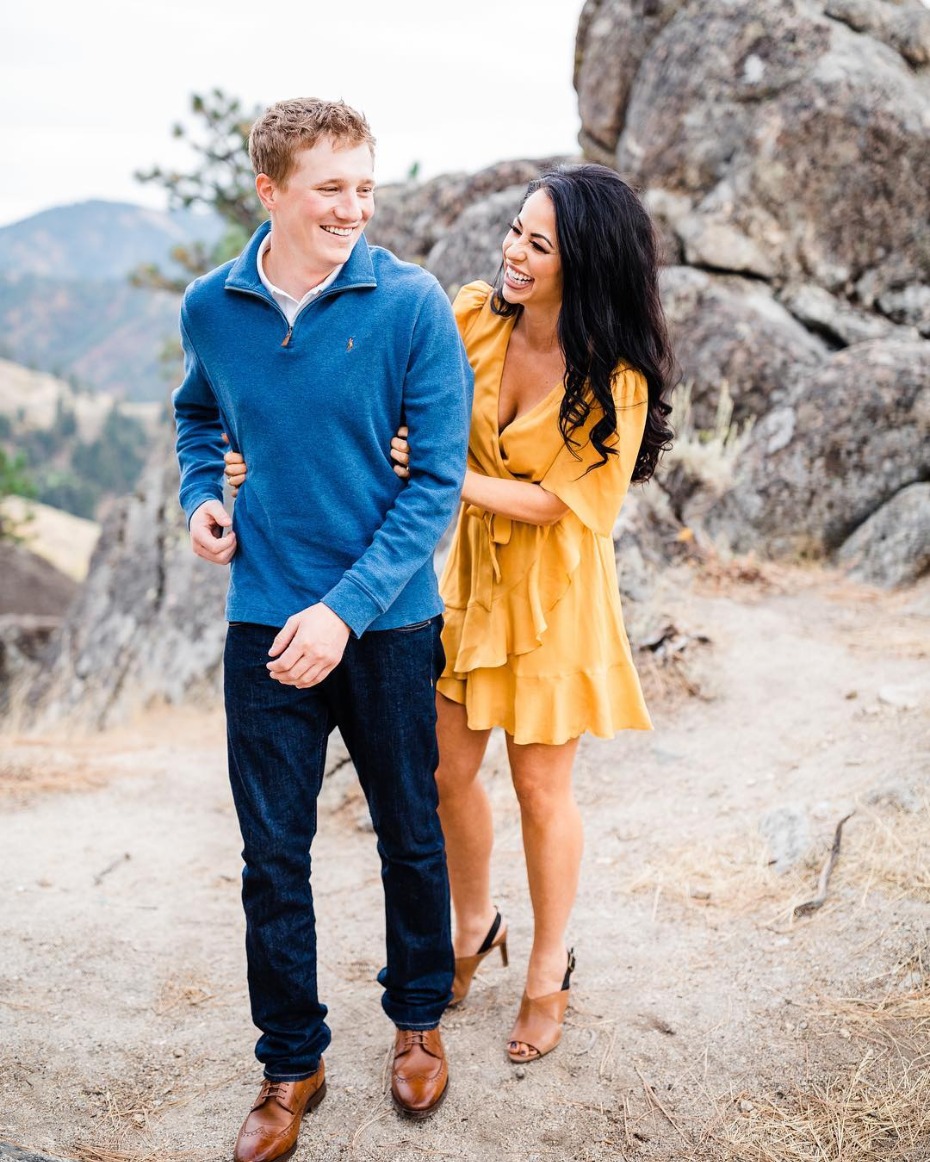 Happy couple laughing outdoors on a mountain trail