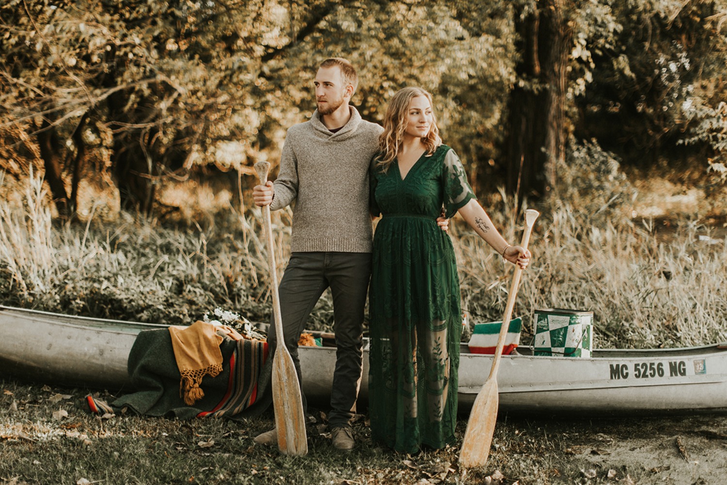 Adventurous couple with paddles beside their canoe
