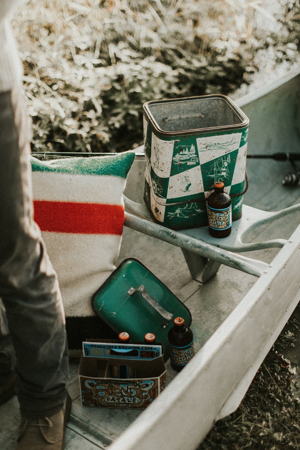 Vintage picnic setup in a boat with drinks and blanket