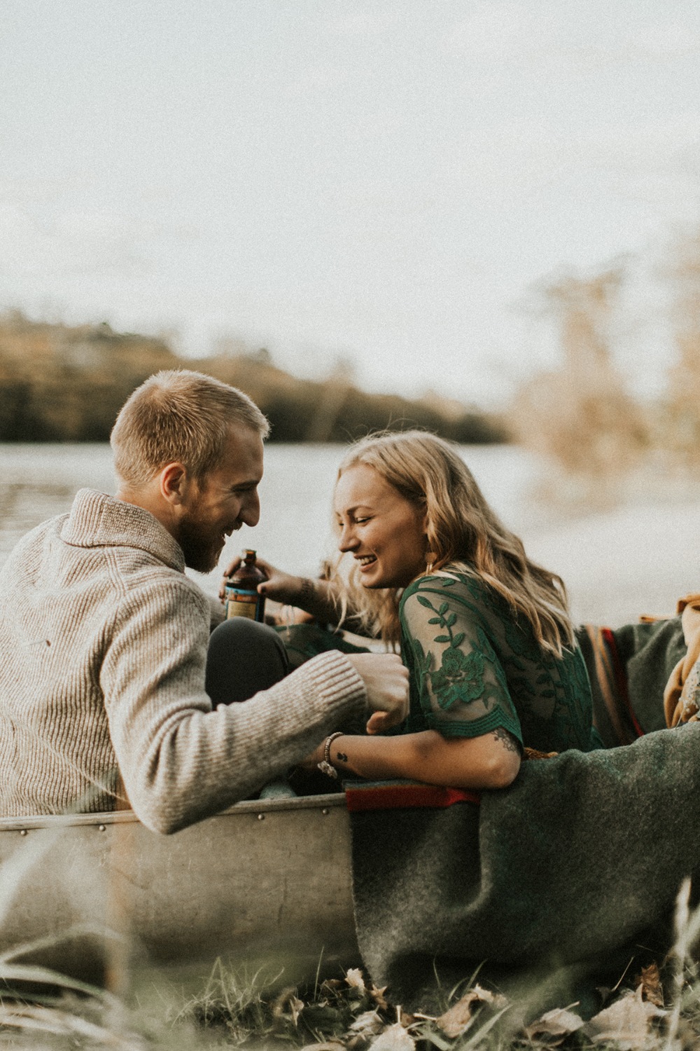 Romantic couple laughing in canoe on fall river date