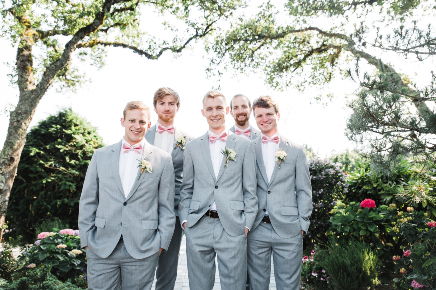 groomsmen in grey suits with pink bowties