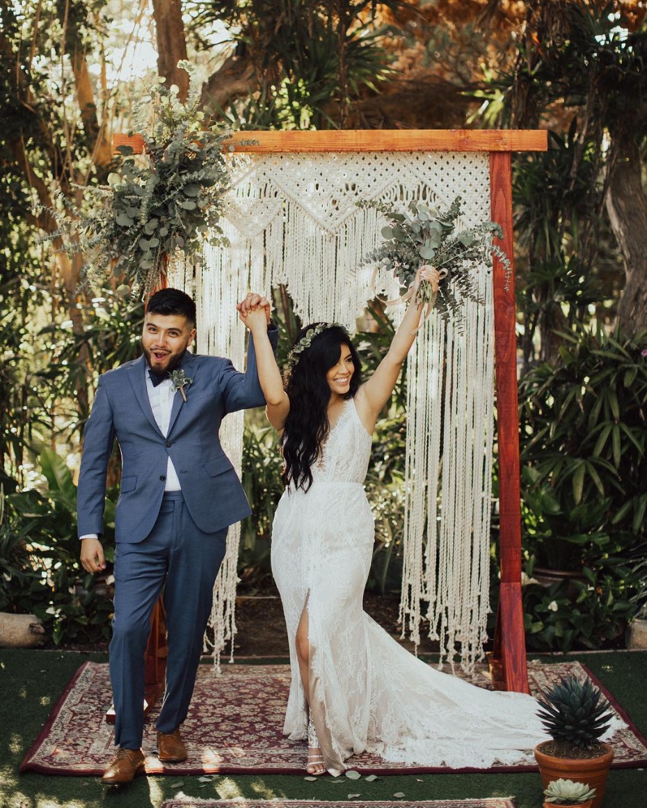 Boho chic wedding happy couple at altar backdrop
