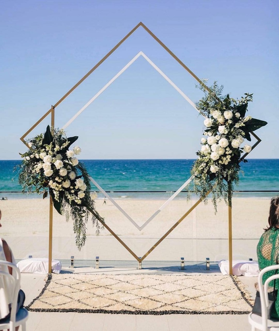 Beach wedding archway with flowers and ocean view