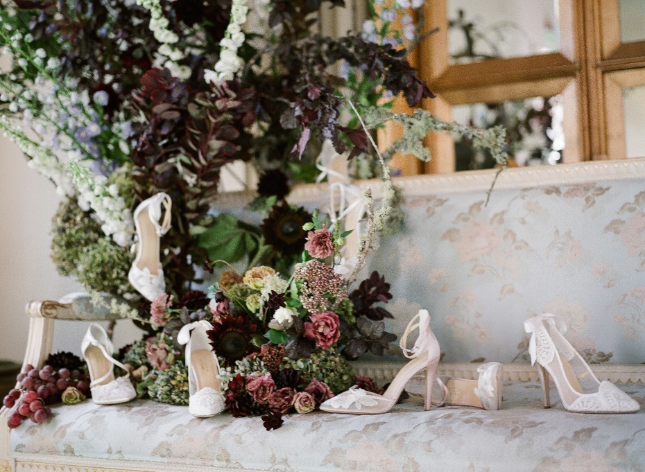 Elegant wedding shoes amid lush floral arrangement