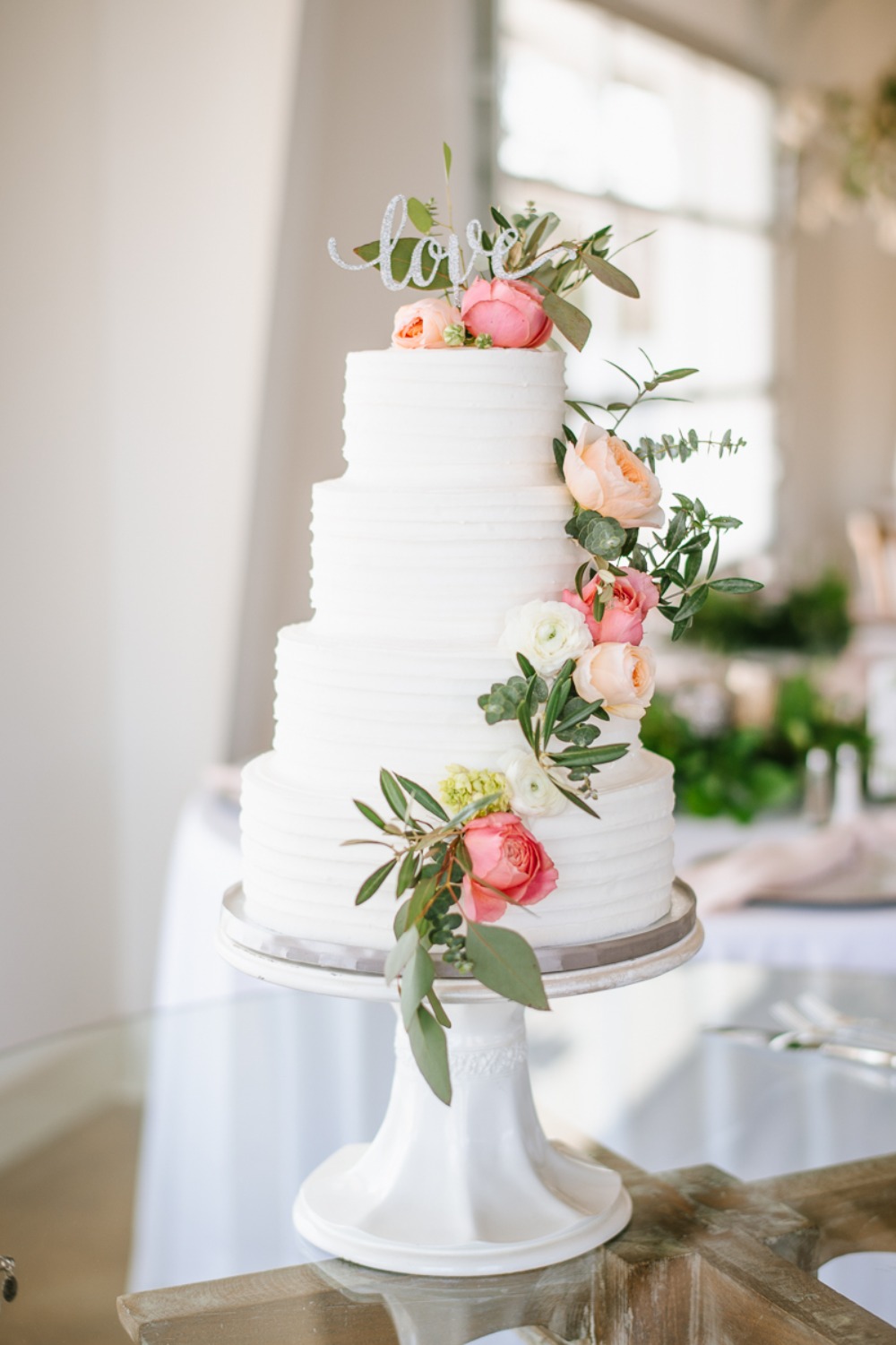 wedding cake with flower and greenery accents