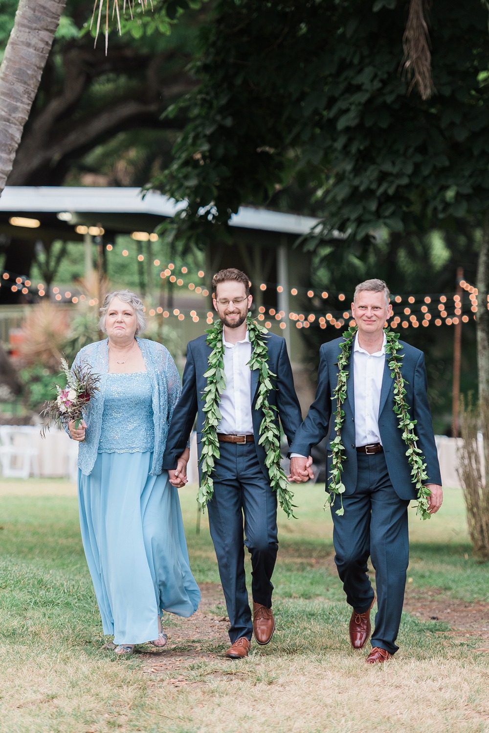 groom being walked down the aisle by mother and father