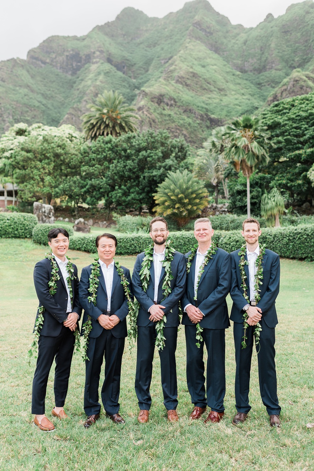 groom and his men in navy suits and greenery garlands