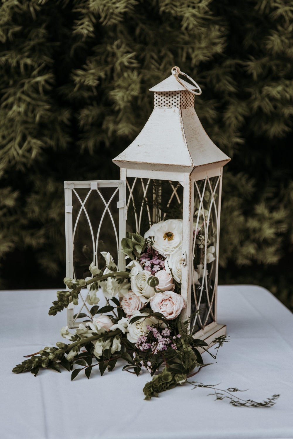 White lantern filled with flowers, perfect for wedding decor