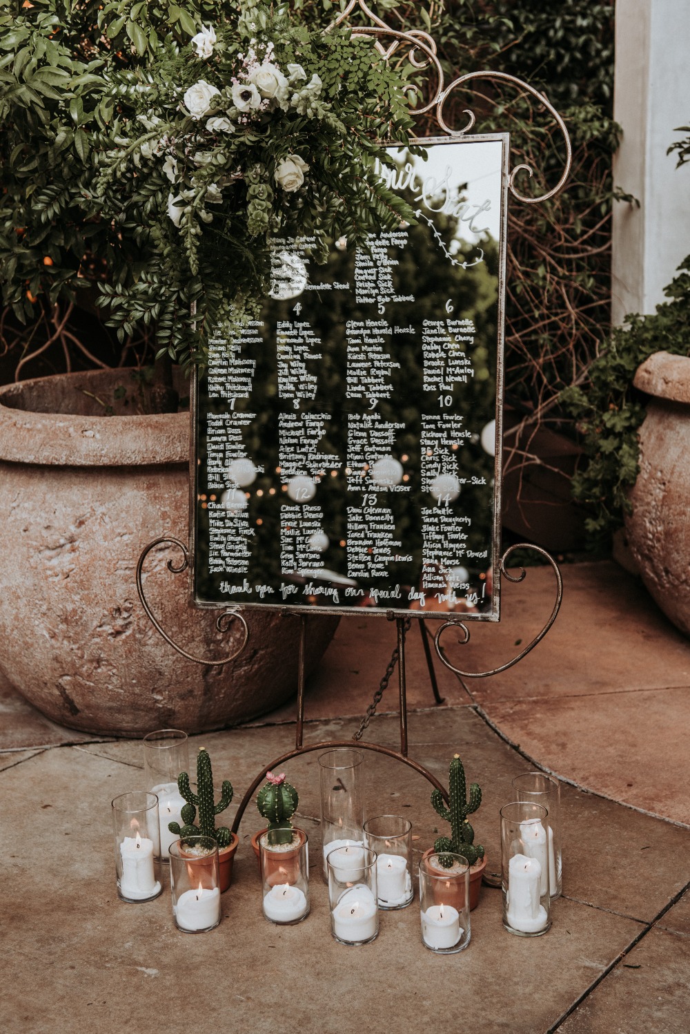 Wedding seating chart mirror with cactus and candles