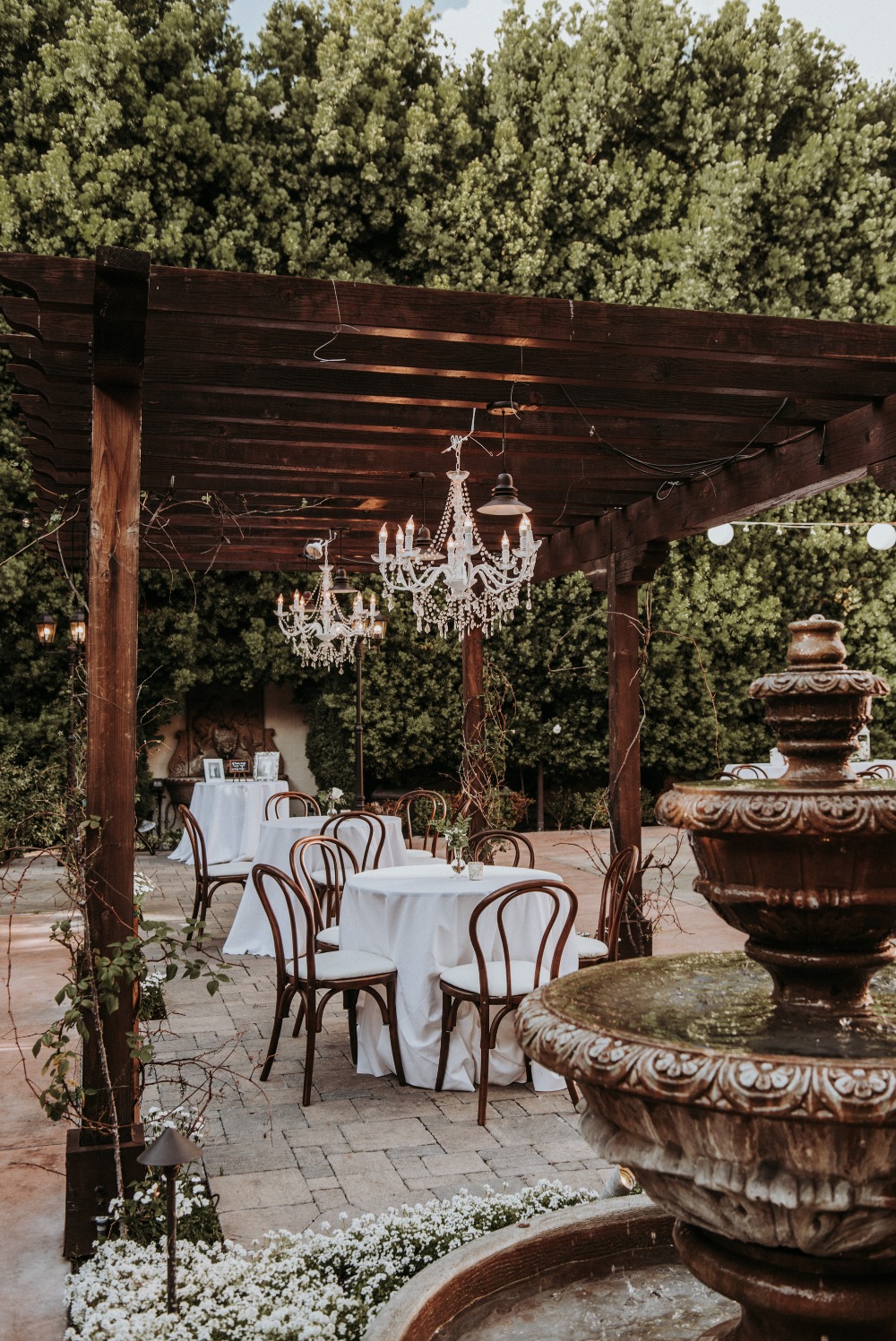 Outdoor reception venue with fountain and chandeliers