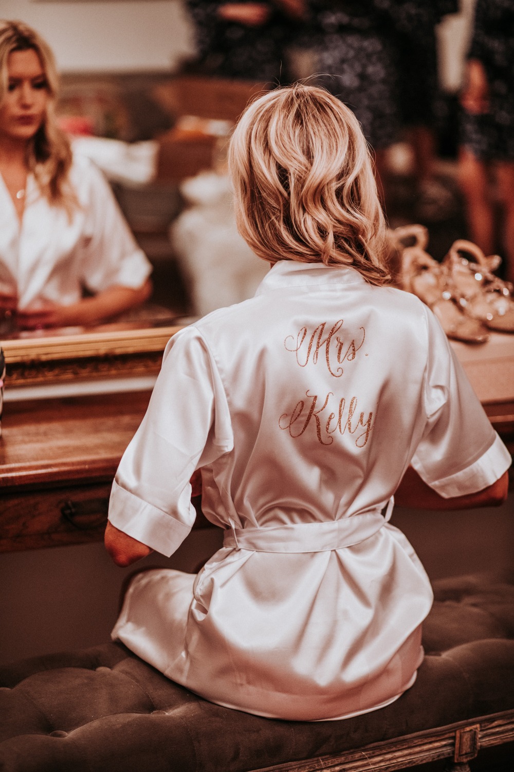 Bride in robe prepares for wedding day Mrs Kelly on back