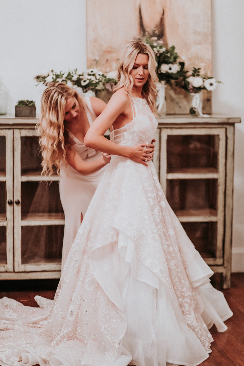 Bride getting dressed in beautiful lace wedding gown