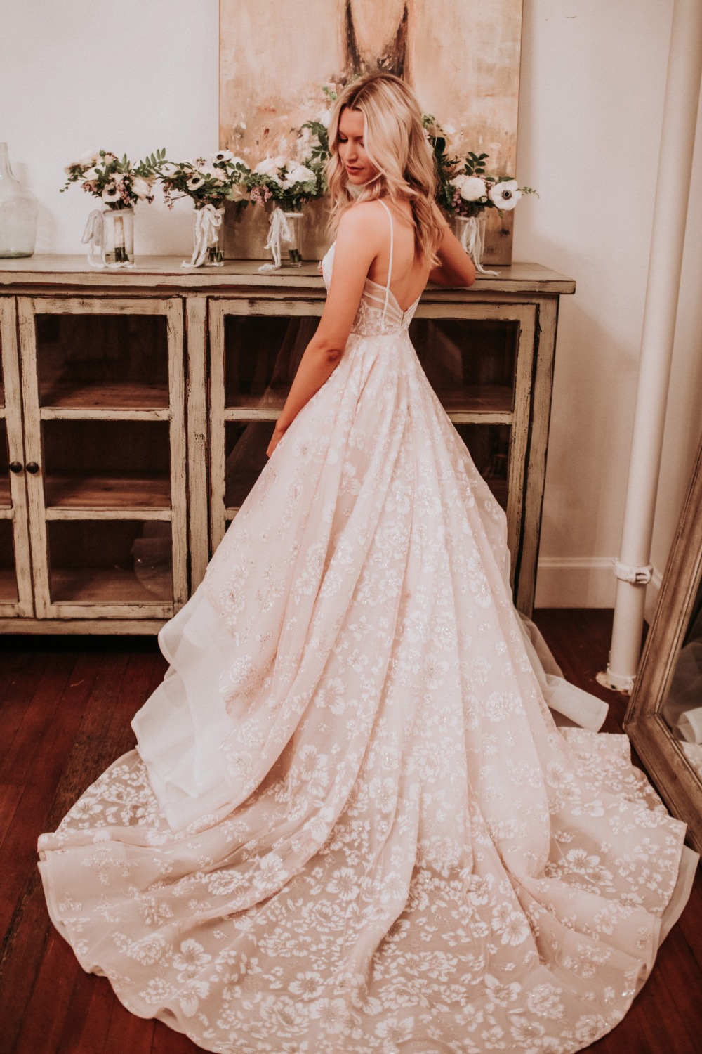 Woman in a flowing lace wedding gown with floral decor