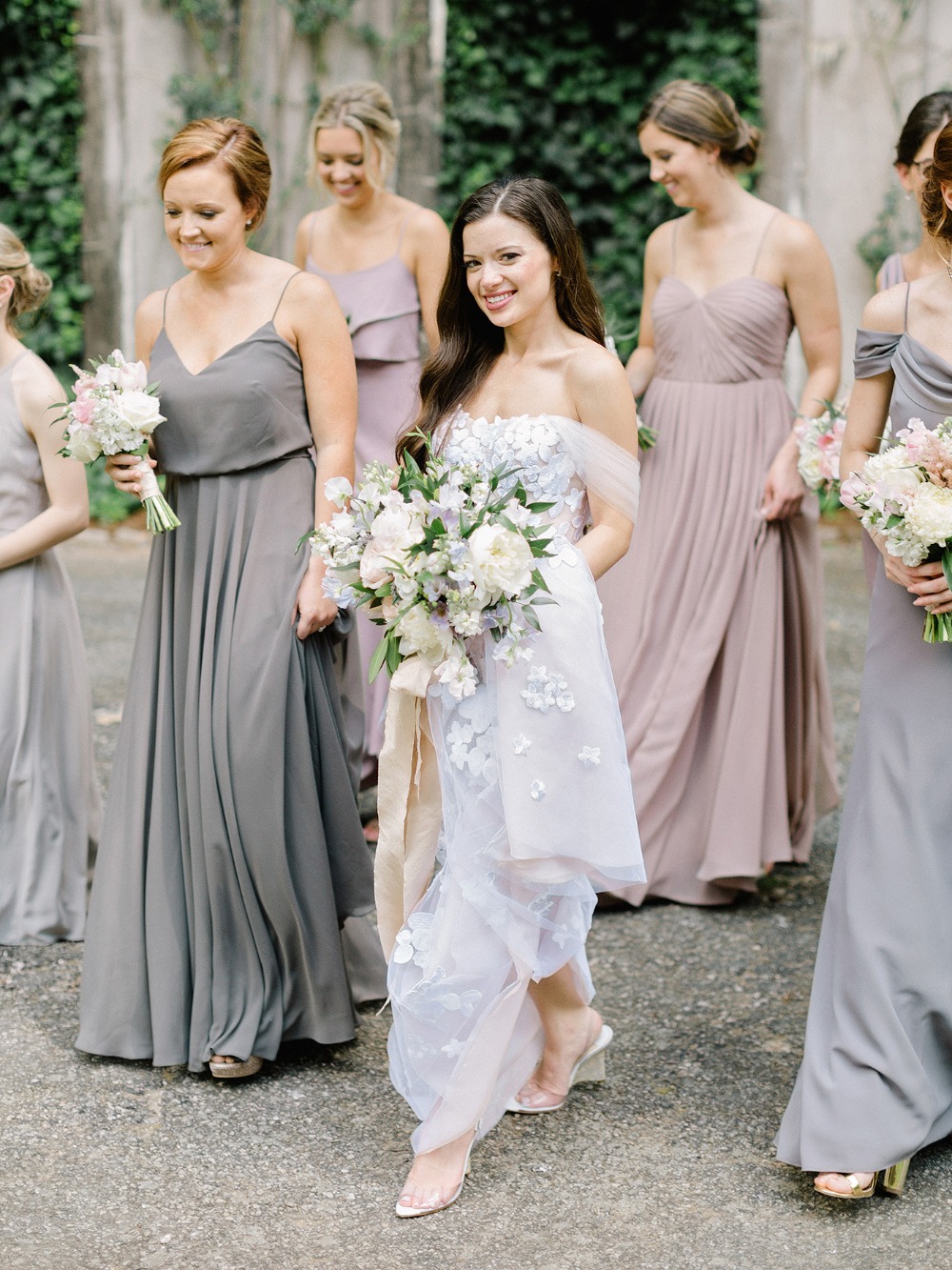 Bride and bridesmaids in elegant gowns and bouquets