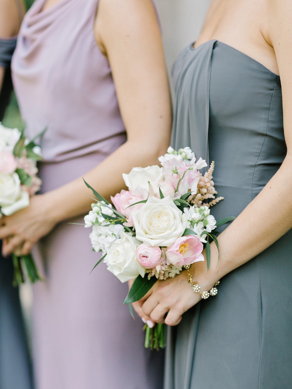 Bridesmaids holding bouquets of white and pink flowers