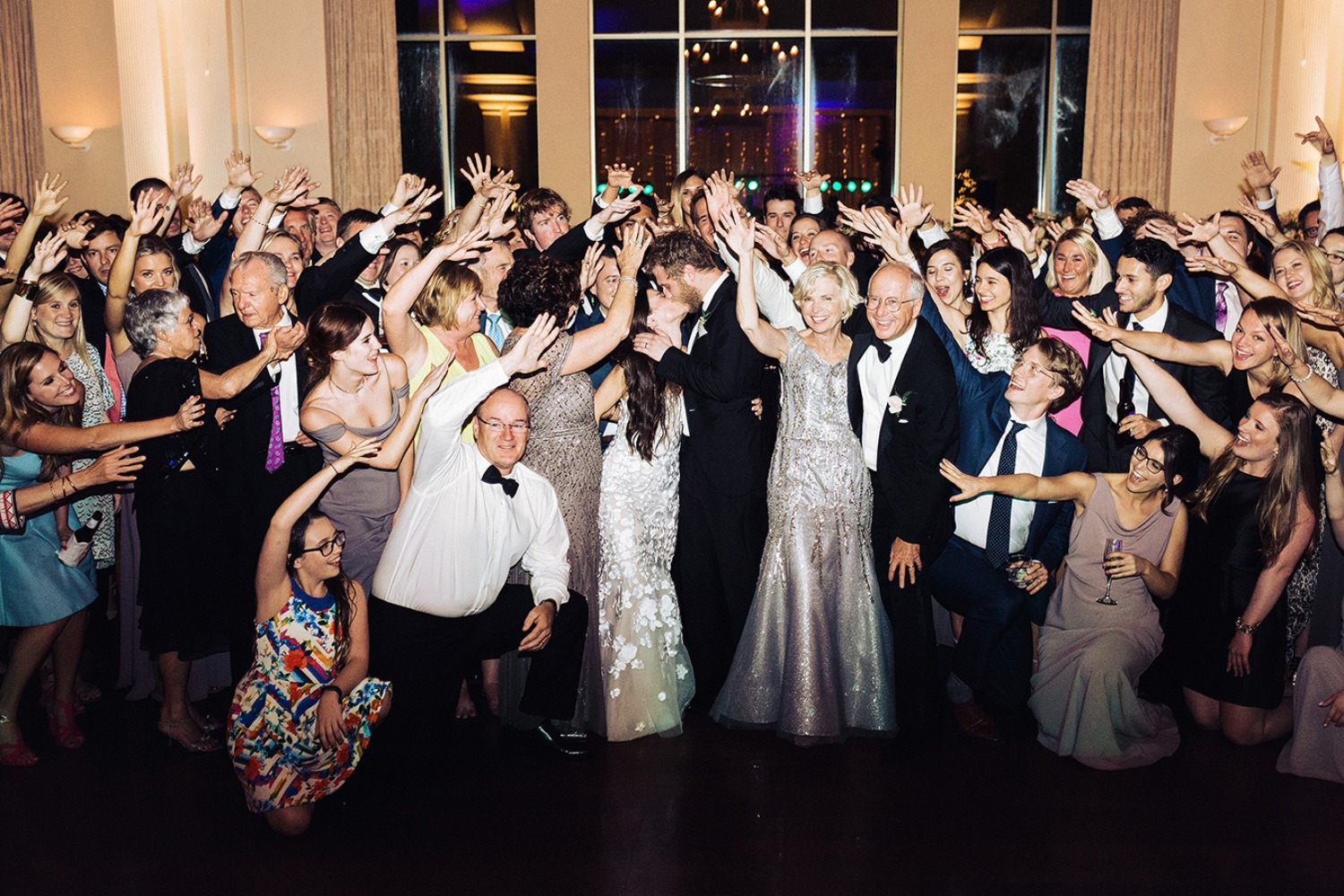 Wedding guests cheer for bride and groom kissing