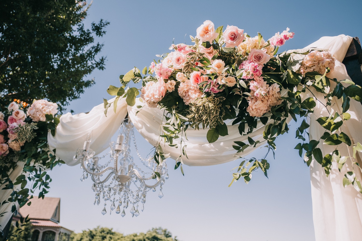 wedding chandelier and flower accented arch