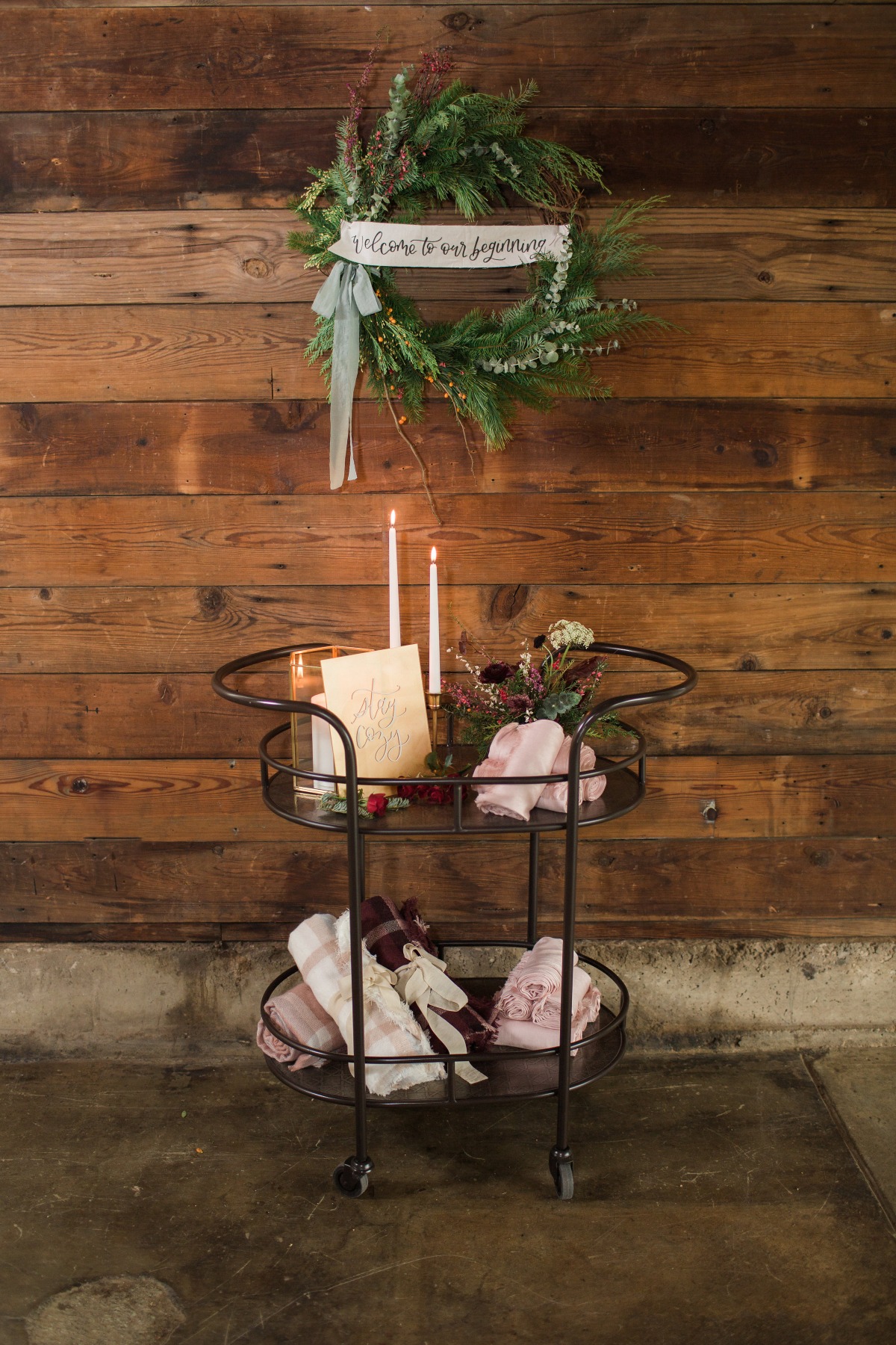 Festive wreath and candlelit cart on a rustic wooden background
