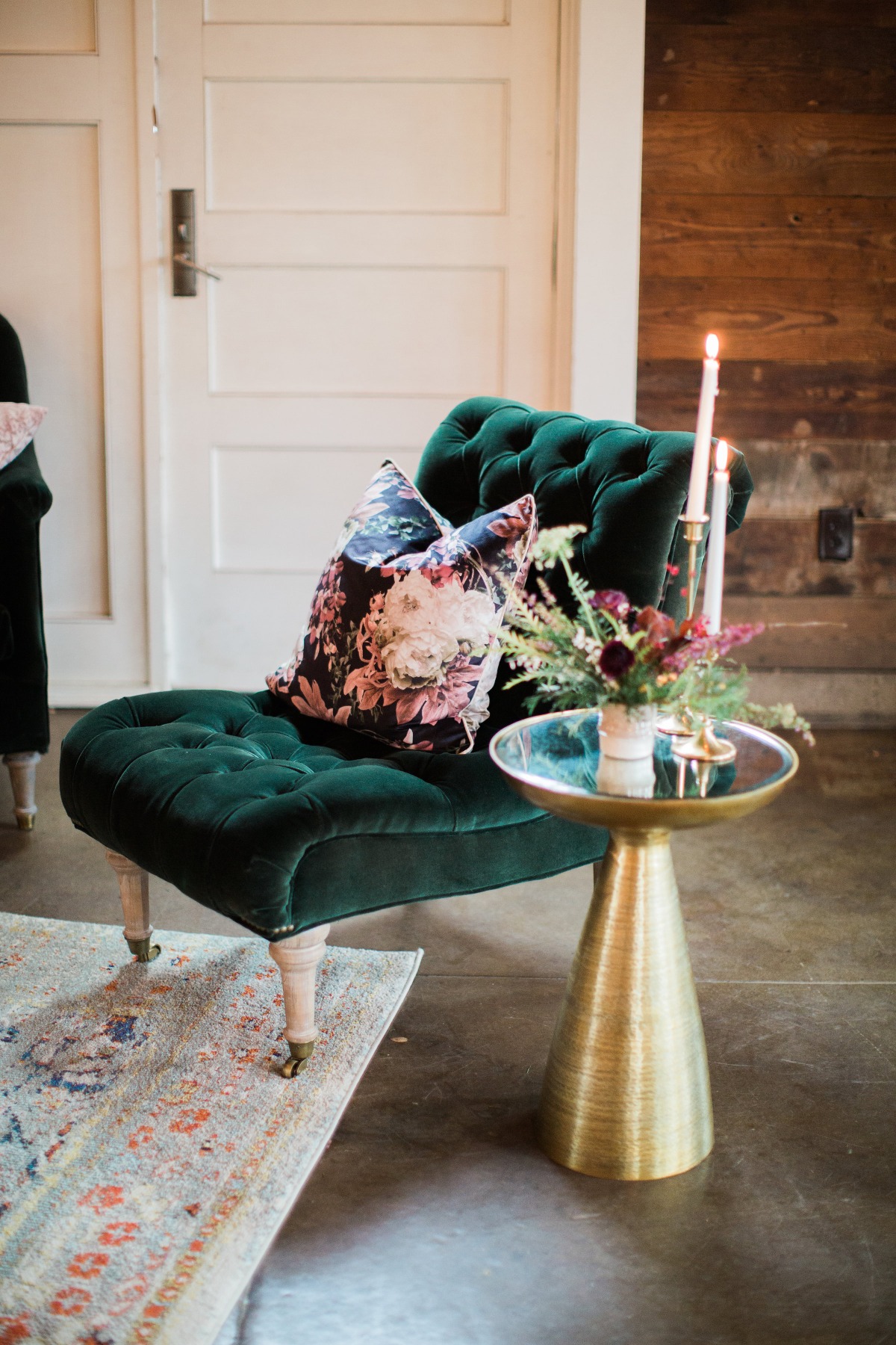 Elegant green velvet chaise lounge with floral pillow and candles