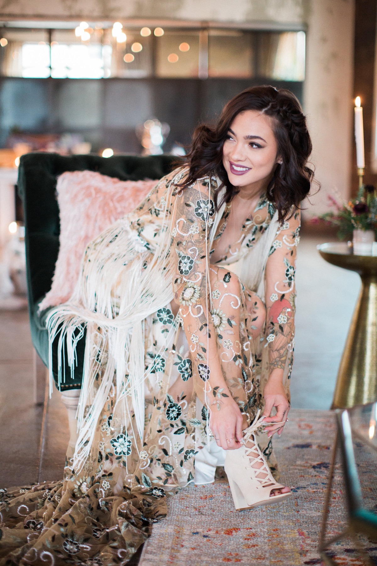 Woman in floral gown tying shoe, smiling elegantly