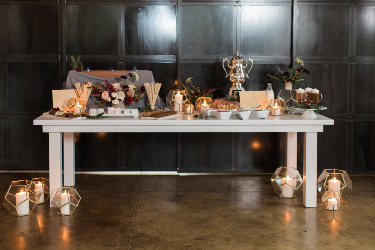 Elegant dessert and drink bar setup with candles and decor