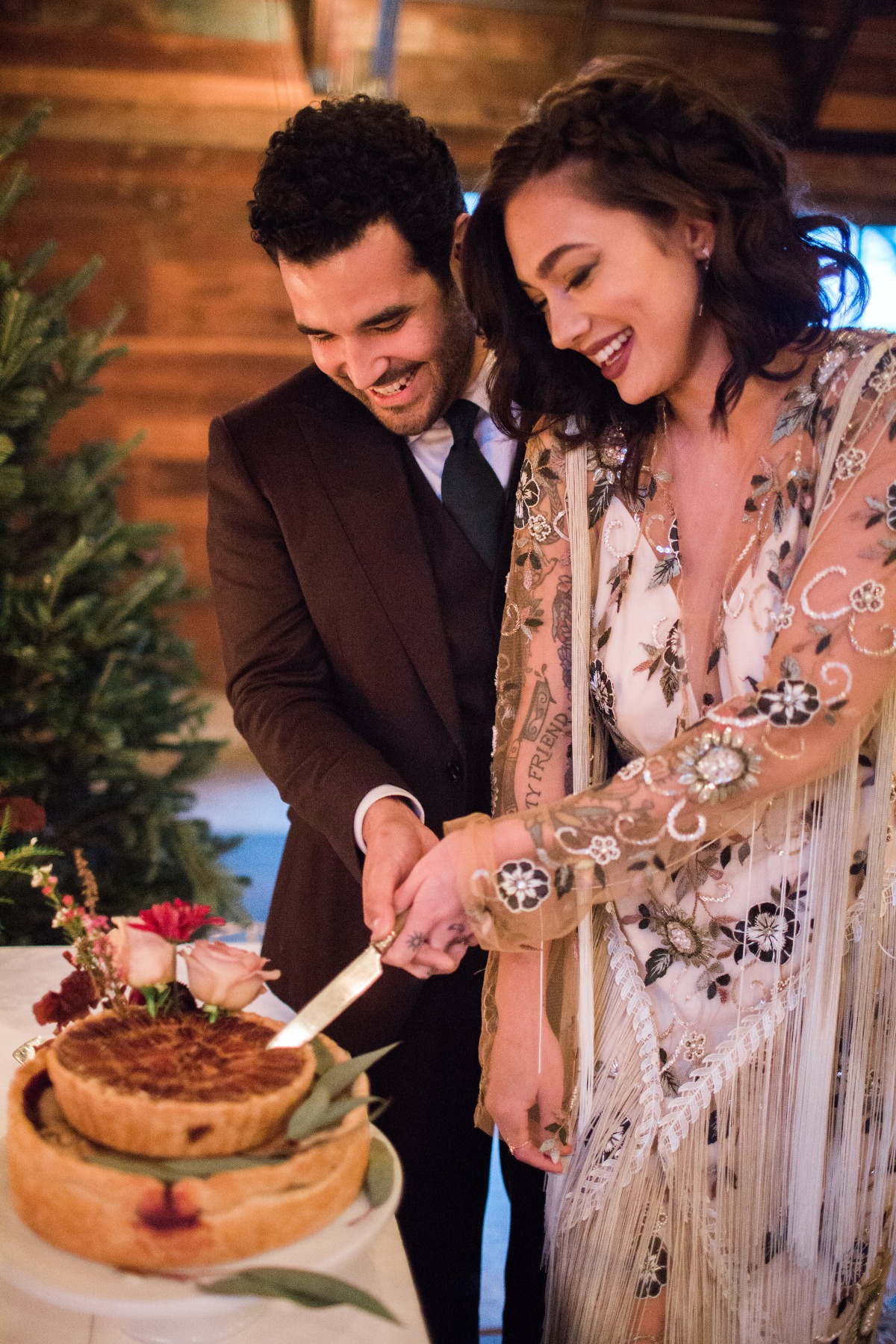Couple cutting wedding cake with smiles and joy at their ceremony