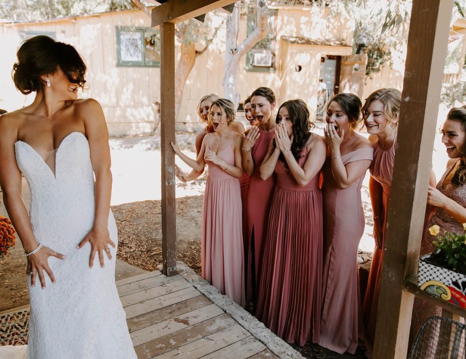 Bride's first look with blush and berry clad bridesmaids