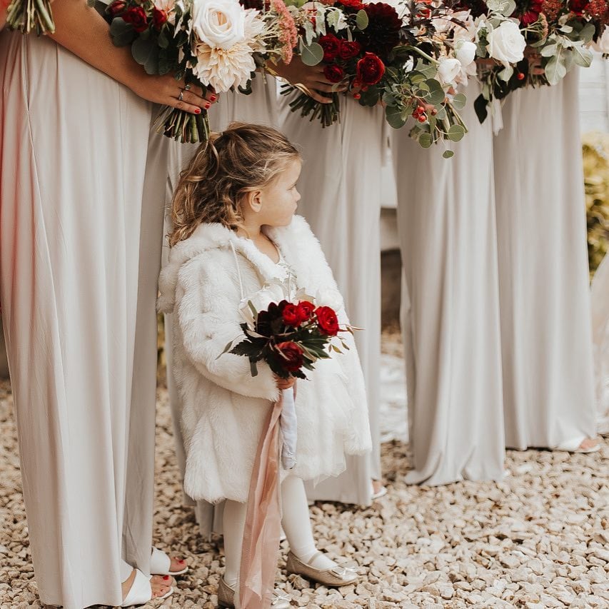 Flower girl in winter coat with curls and ballet flats