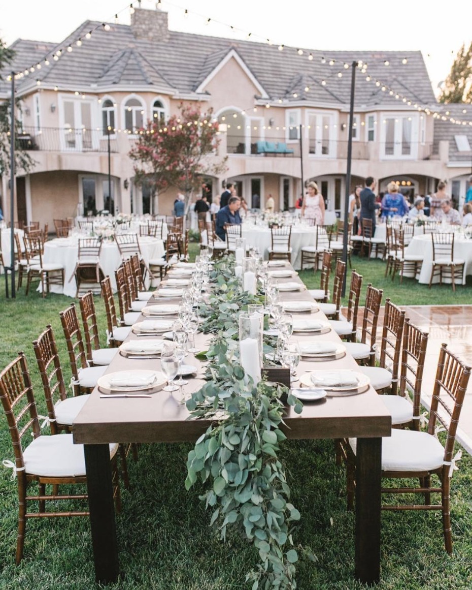 Backyard wedding with farm tables and floral garlands
