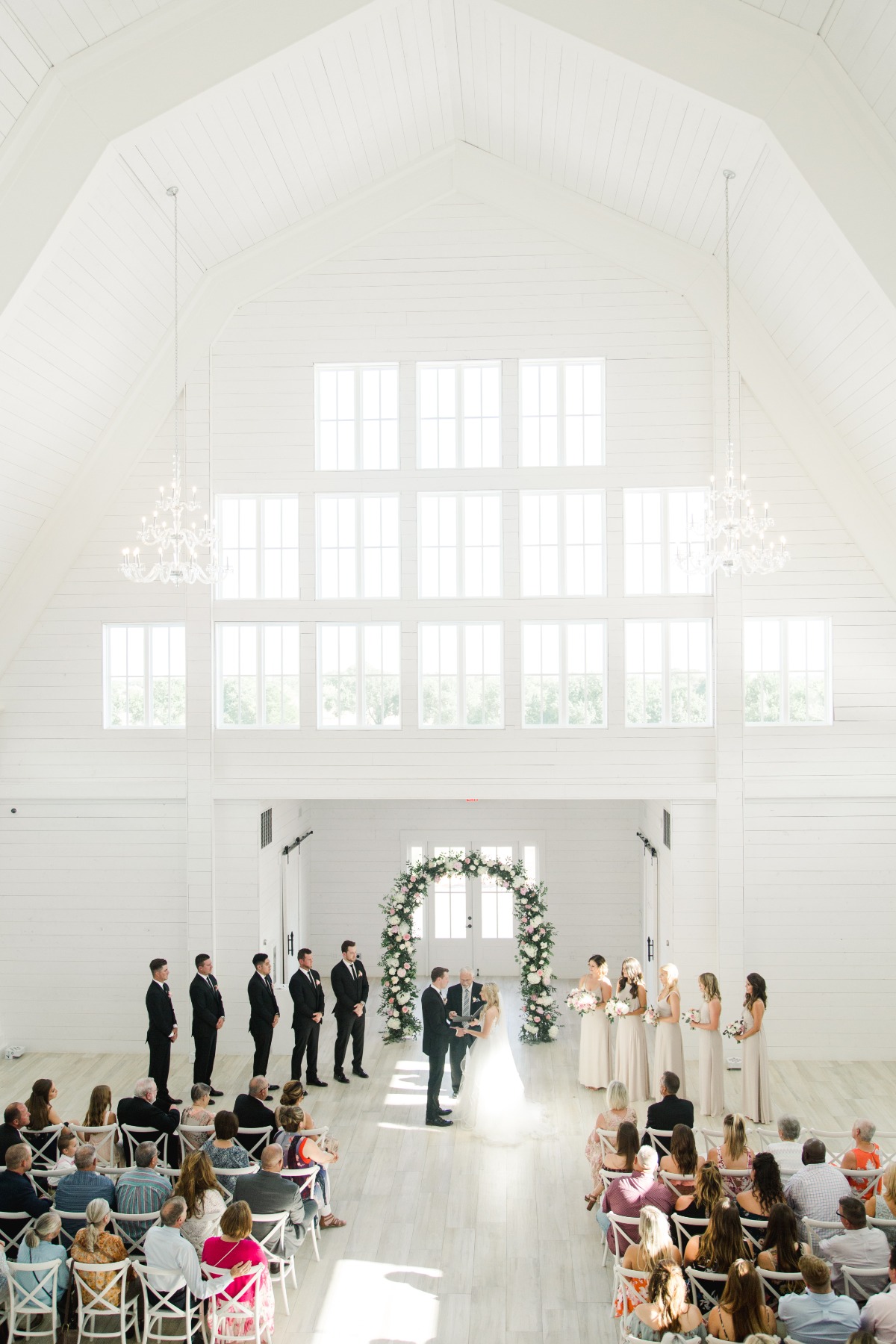 Elegant indoor wedding ceremony in a bright, white venue
