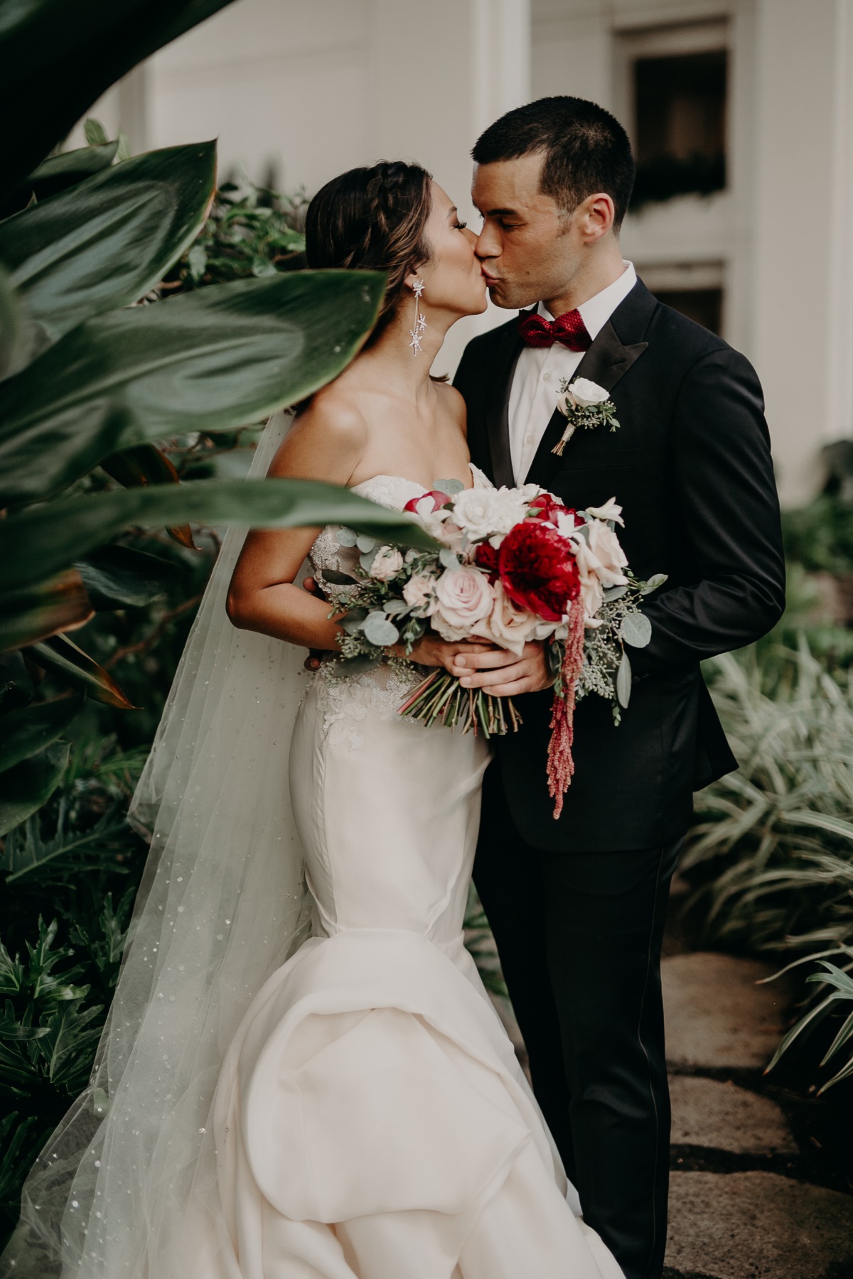 Newlyweds sharing a kiss in the garden on their wedding day