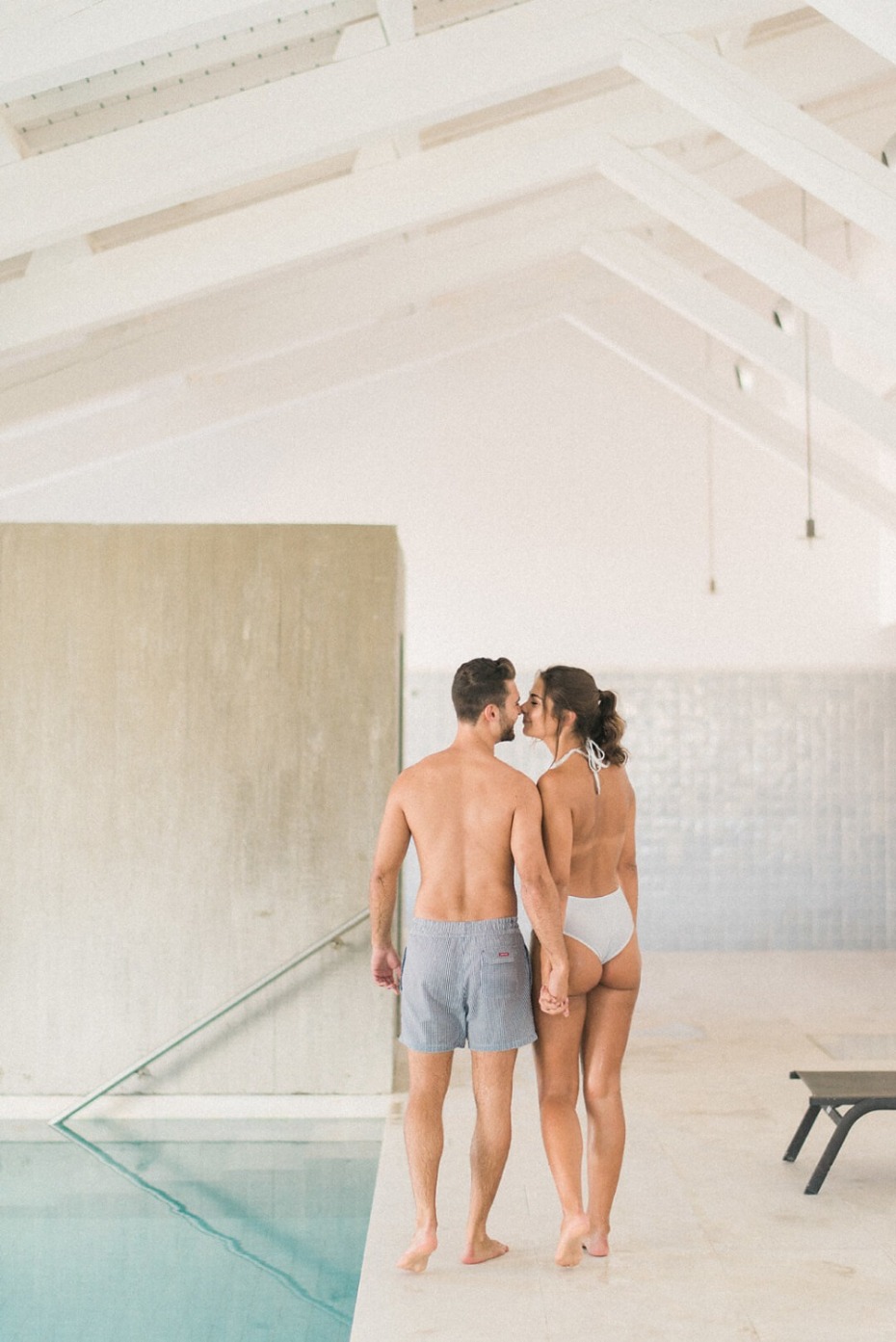 Couple kissing by a pool, romantic getaway