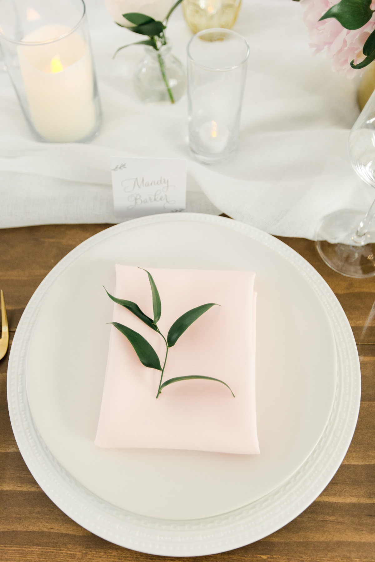 Elegant table setting with plate, napkin, and greenery decoration