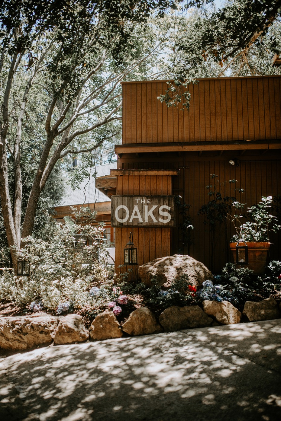 The Oaks building facade with flowers and greenery