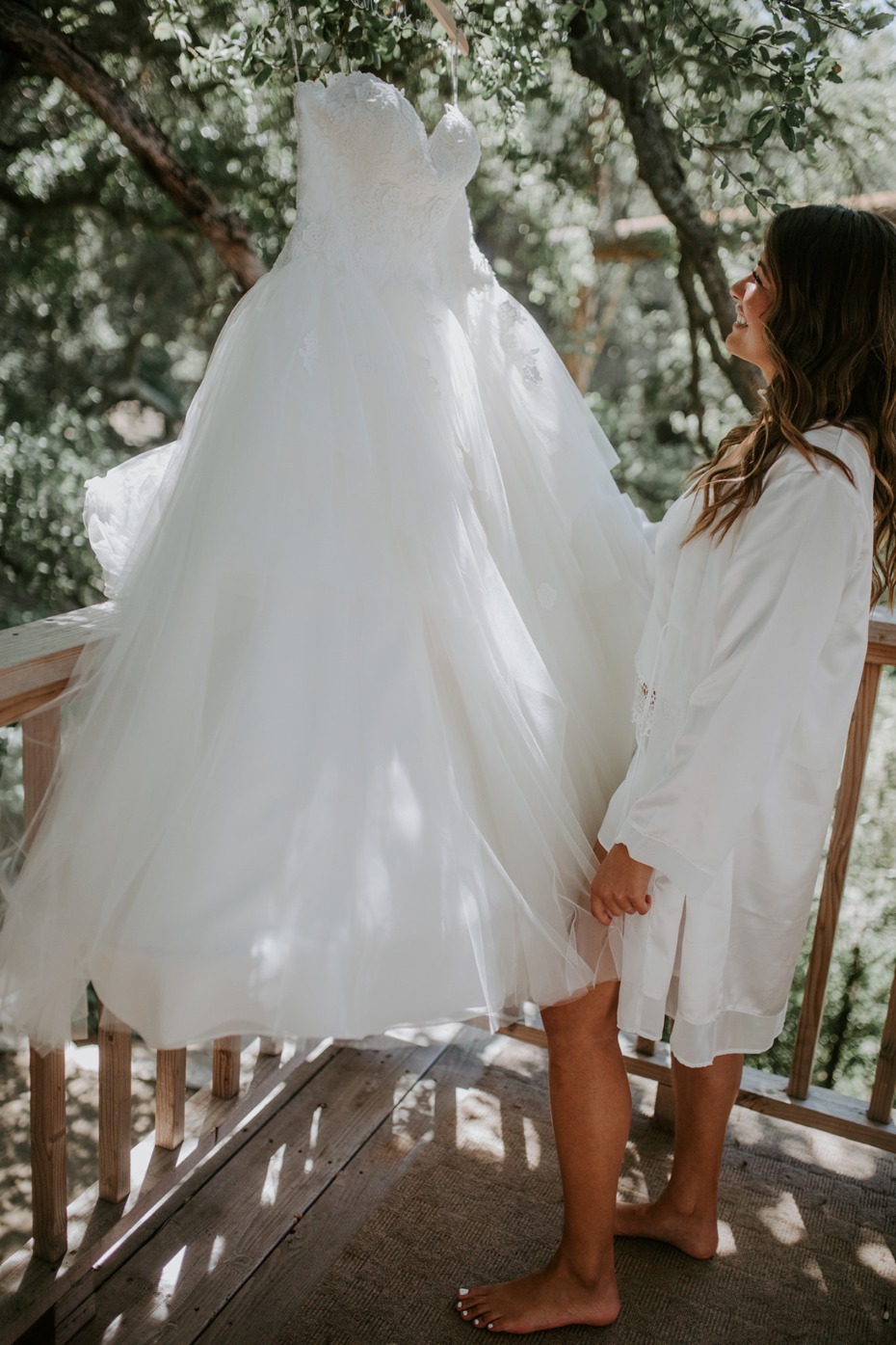 Bride admiring her beautiful wedding gown outdoors