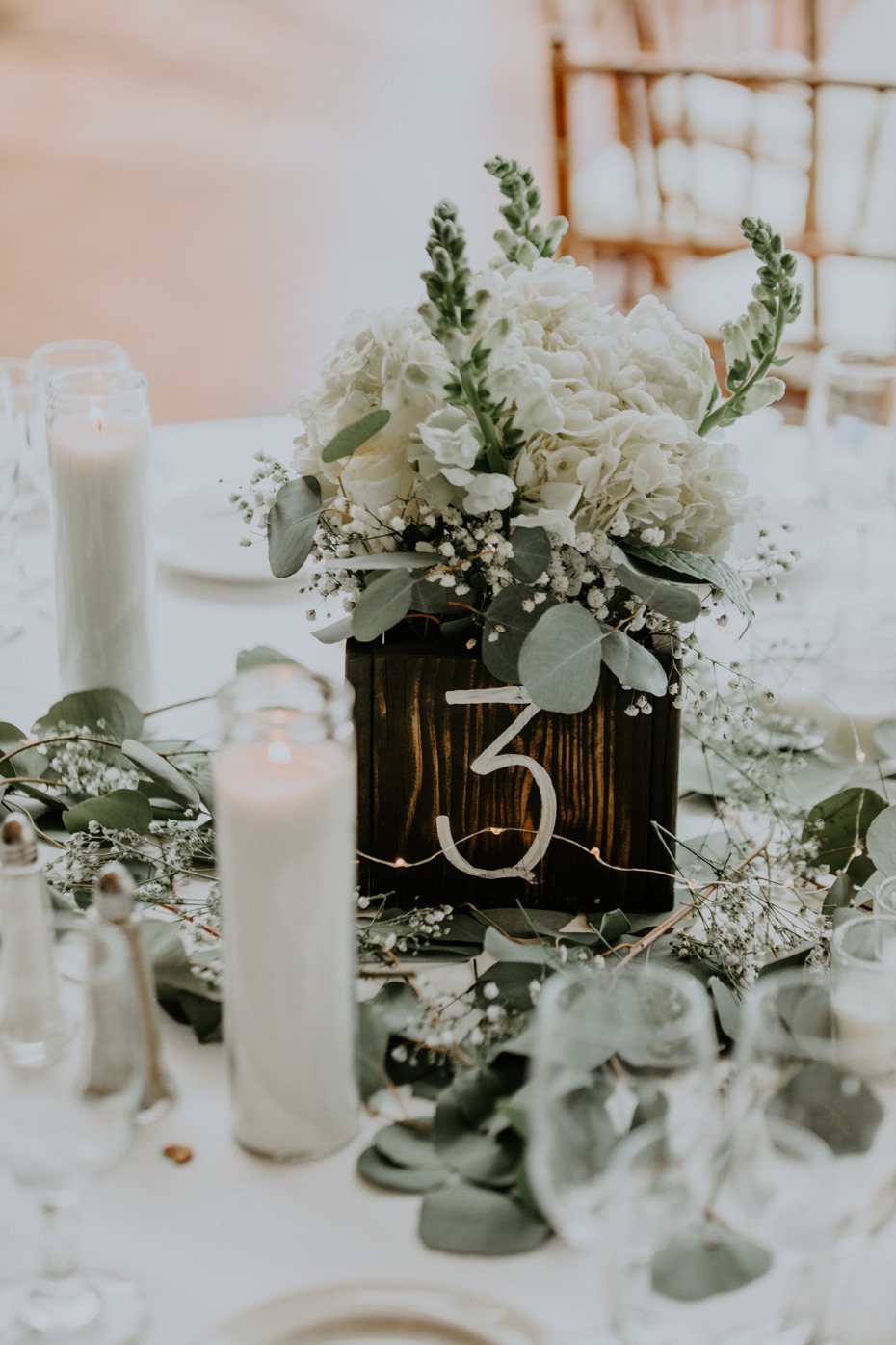 Wedding table setting with floral arrangement and number three